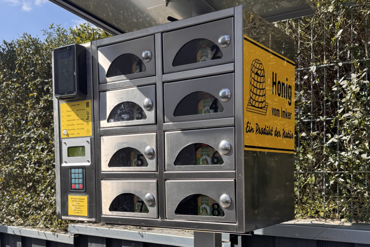 24/7 Honigautomat Selbstbedienungs-Honigautomat aus Edelstahl mit mehreren Fächern und Bezahlterminal.